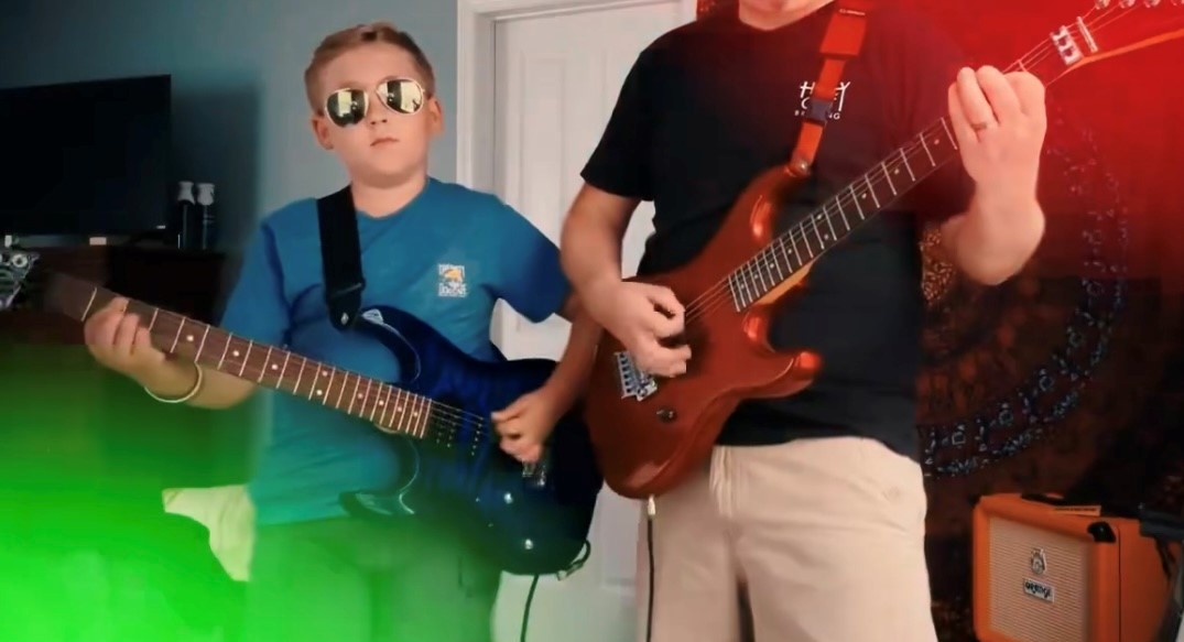 Marcus Rhymer and his son playing guitar